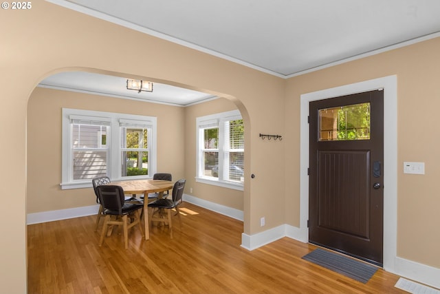 3305 NE Siskiyou St, Portland, OR 97212 - entrance foyer featuring arched walkways, light wood-style flooring, ornamental molding, and baseboards