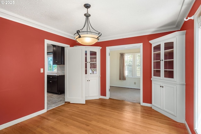 205 NE Billingher Dr, Portland, OR 97220 - unfurnished dining area with crown molding, plenty of natural light, light wood-style flooring, and baseboards