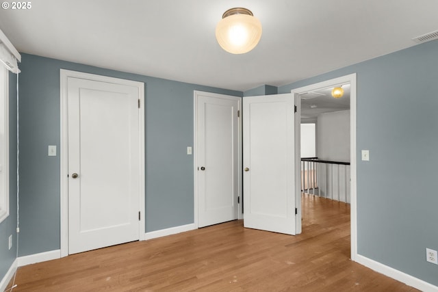 205 NE Billingher Dr, Portland, OR 97220 - unfurnished bedroom with visible vents, wood finished floors, baseboards, and multiple closets