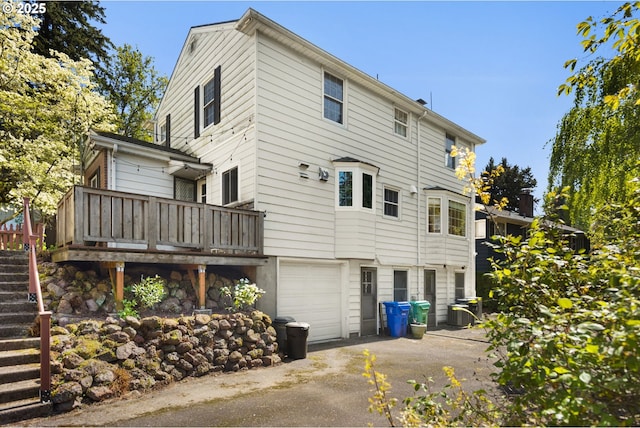 205 NE Billingher Dr, Portland, OR 97220 - back of house featuring stairway, aphalt driveway, a deck, and a garage