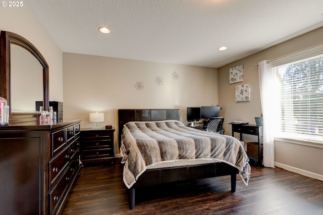 bedroom featuring dark hardwood / wood-style flooring and a textured ceiling