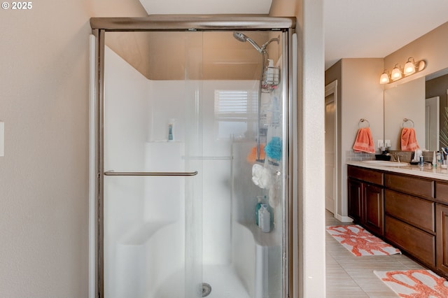 bathroom with vanity, a shower with shower door, and tile patterned flooring