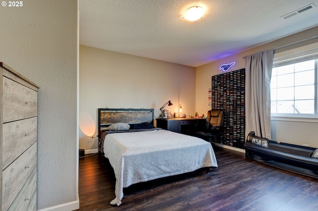 bedroom with dark wood-type flooring and a textured ceiling