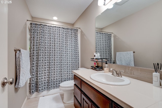 bathroom featuring vanity, curtained shower, and toilet