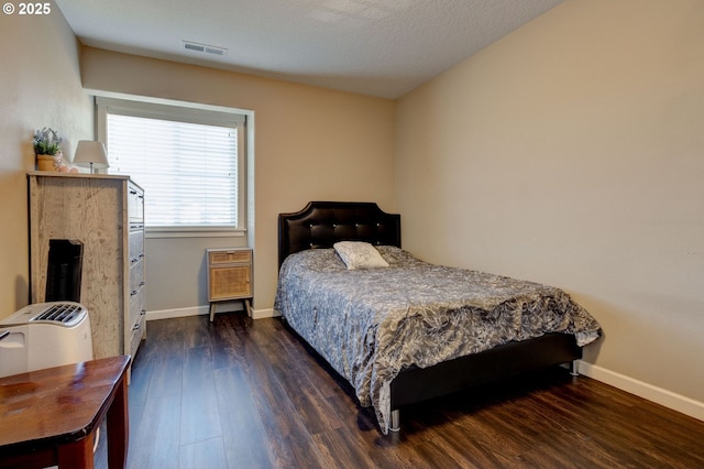 bedroom with dark hardwood / wood-style floors