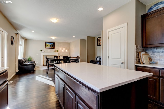 kitchen with tasteful backsplash, a kitchen island, dark hardwood / wood-style floors, and dark brown cabinetry