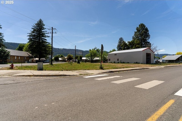 305 N Main St, Halfway, OR 97834 - view of asphalt road featuring sidewalks, curbs, and a pole building
