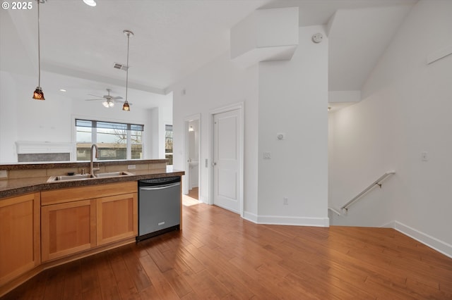 kitchen with dark wood-type flooring, sink, decorative light fixtures, stainless steel dishwasher, and ceiling fan