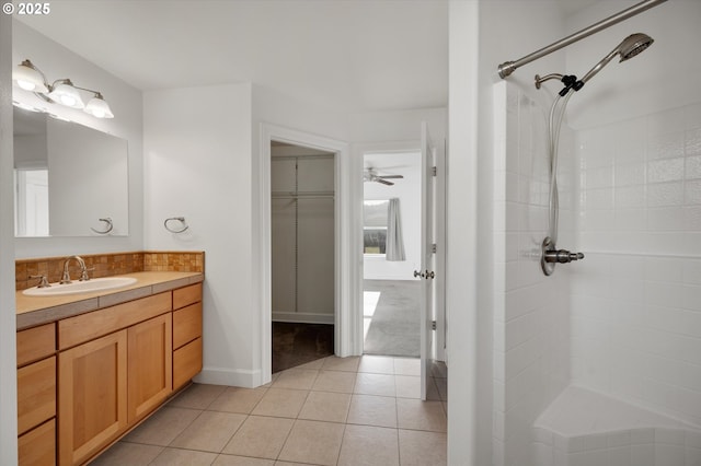 bathroom with tile patterned flooring, vanity, and walk in shower