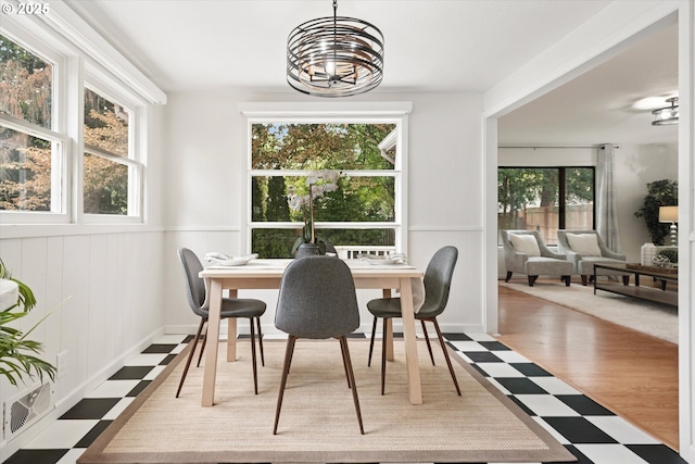 10914 SW 64th Ave, Portland, OR 97219 - dining area with tile patterned floors, wainscoting, and a chandelier