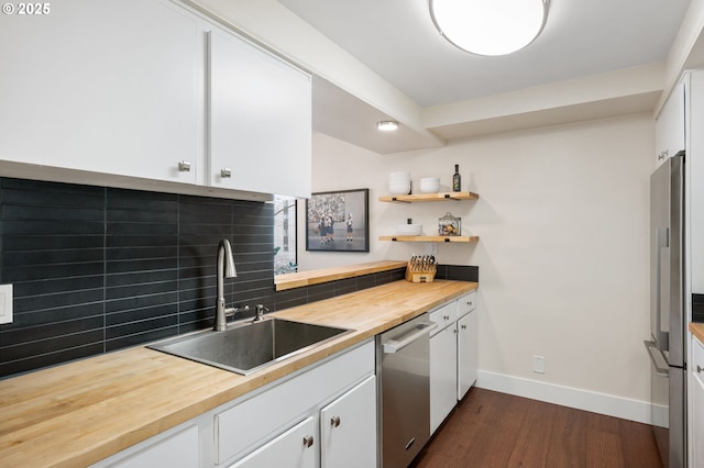 kitchen with a sink, wood counters, tasteful backsplash, stainless steel appliances, and dark wood-style flooring