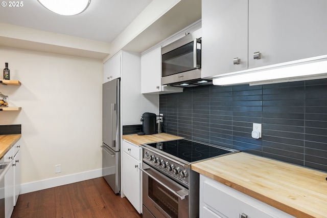 kitchen featuring decorative backsplash, appliances with stainless steel finishes, white cabinets, wood counters, and dark wood-style flooring