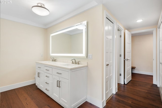 bathroom featuring a sink, baseboards, and wood finished floors