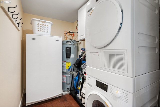 clothes washing area featuring stacked washer / drying machine, dark wood-style flooring, and water heater