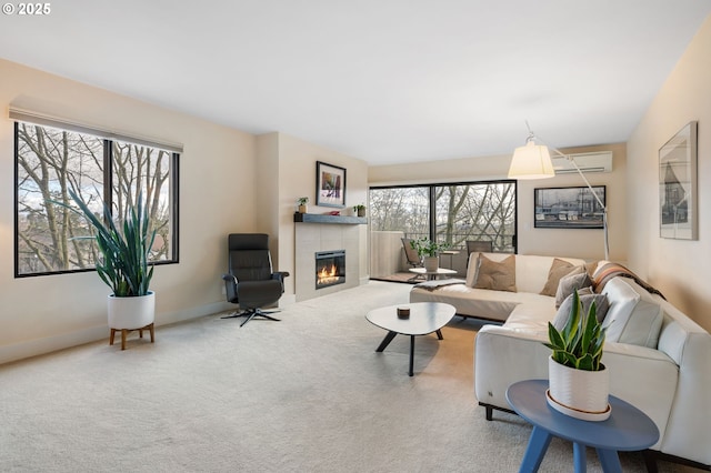 living area featuring a tiled fireplace, carpet flooring, baseboards, and a wall mounted AC