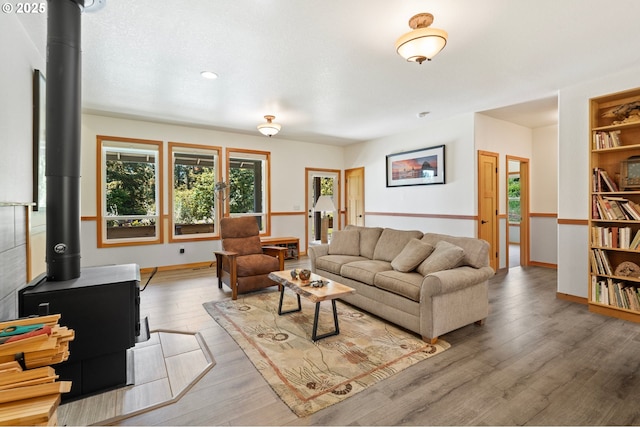 66020 Meissner Rd, Deer Island, OR 97054 - living area featuring a wood stove, wood finished floors, and baseboards