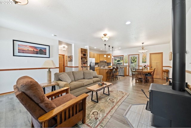 66020 Meissner Rd, Deer Island, OR 97054 - living room featuring a wood stove, recessed lighting, baseboards, and light wood-style flooring