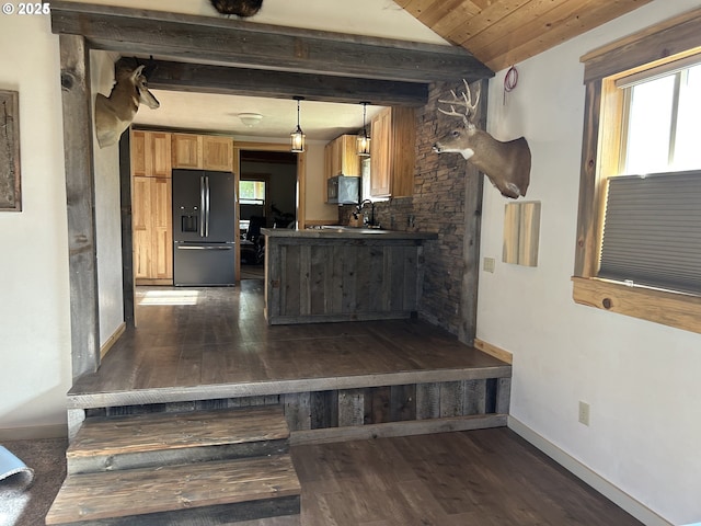 kitchen featuring black appliances, dark countertops, plenty of natural light, beam ceiling, and a peninsula