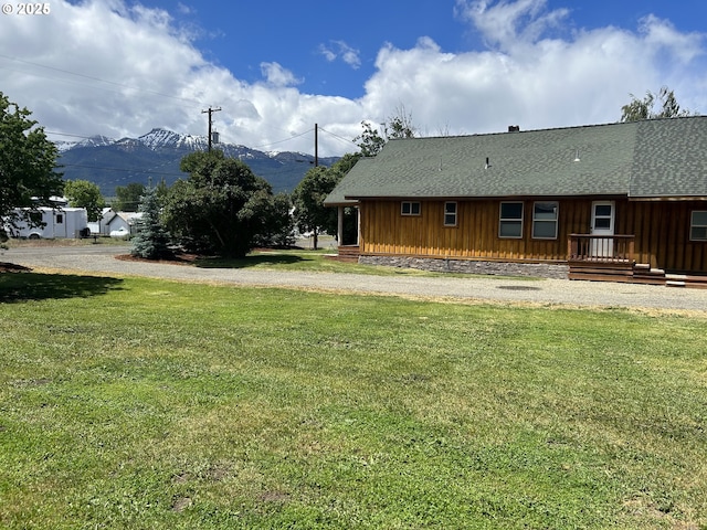 rear view of property with a lawn, board and batten siding, and roof with shingles