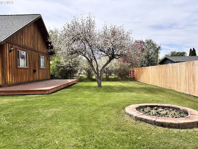 view of yard with a deck and an outdoor fire pit