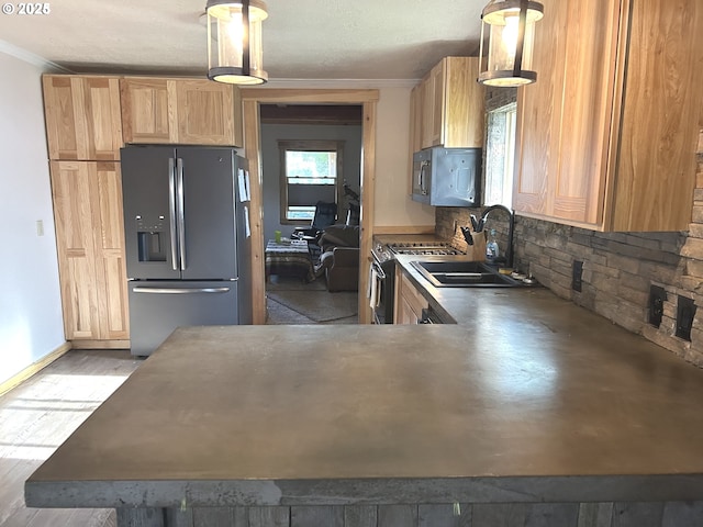 kitchen featuring appliances with stainless steel finishes, a sink, ornamental molding, backsplash, and pendant lighting