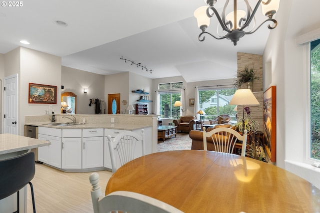 dining area with track lighting, a notable chandelier, recessed lighting, and light wood-type flooring