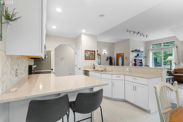 kitchen with a peninsula, a sink, white cabinets, electric stove, and open floor plan