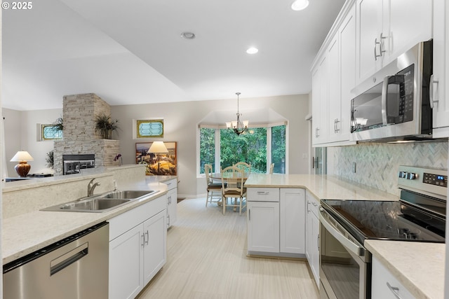 kitchen with a sink, backsplash, white cabinetry, stainless steel appliances, and light countertops