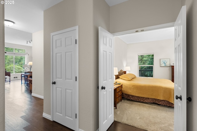 bedroom with baseboards and dark wood-style floors