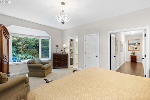 bedroom with an inviting chandelier, carpet flooring, baseboards, and ensuite bathroom