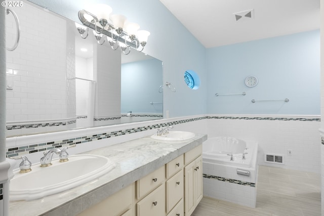 bathroom with a sink, visible vents, and a garden tub