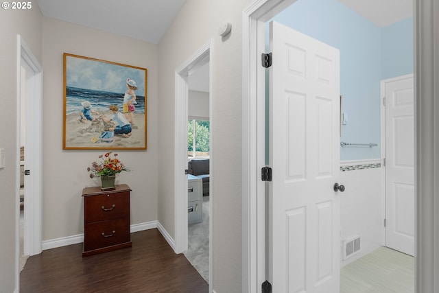 hallway with visible vents and wood finished floors