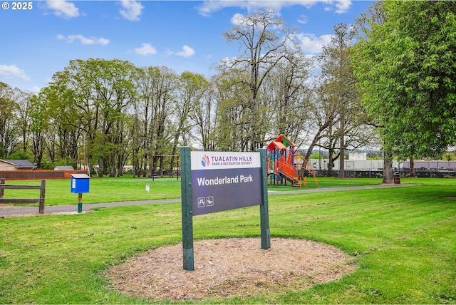 view of home's community featuring fence, a yard, and playground community