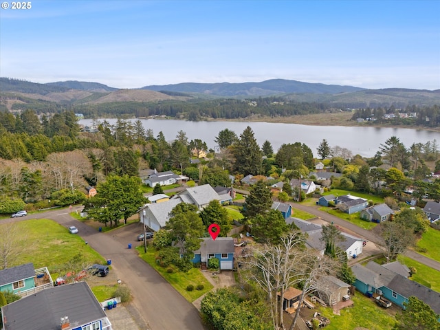 birds eye view of property with a view of trees, a water and mountain view, and a residential view