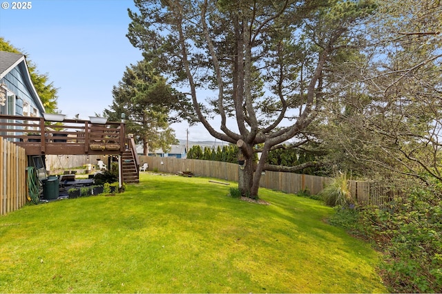 view of yard featuring a fenced backyard, a wooden deck, and stairs