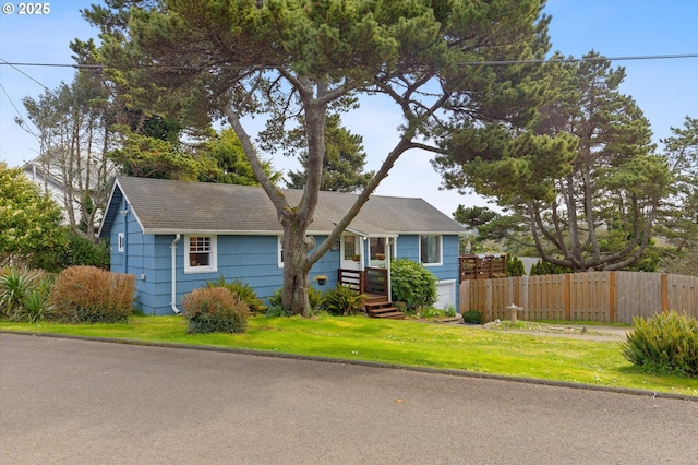 view of front of property with fence and a front lawn