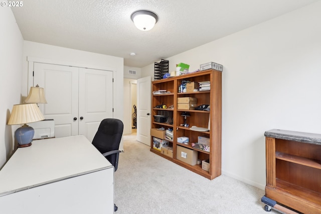 office space with light carpet, baseboards, visible vents, and a textured ceiling