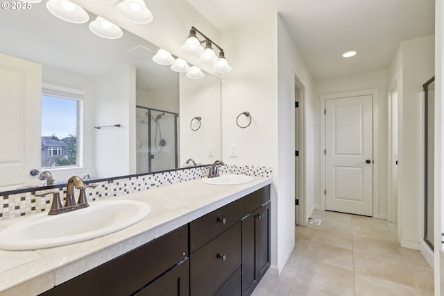 full bath with double vanity, a stall shower, tile patterned flooring, and a sink