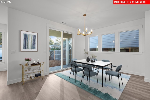 dining area with hardwood / wood-style floors and a chandelier