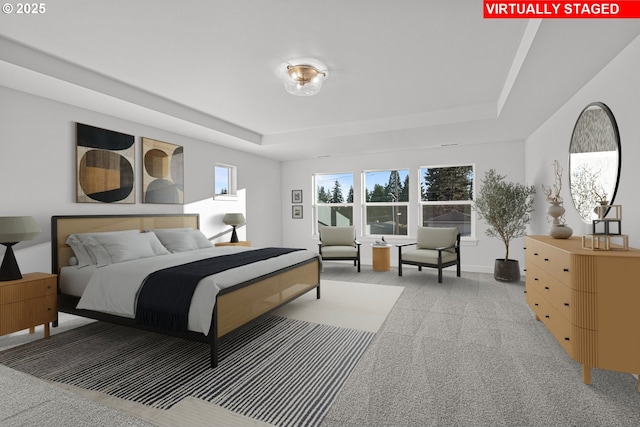 bedroom featuring light colored carpet and a raised ceiling