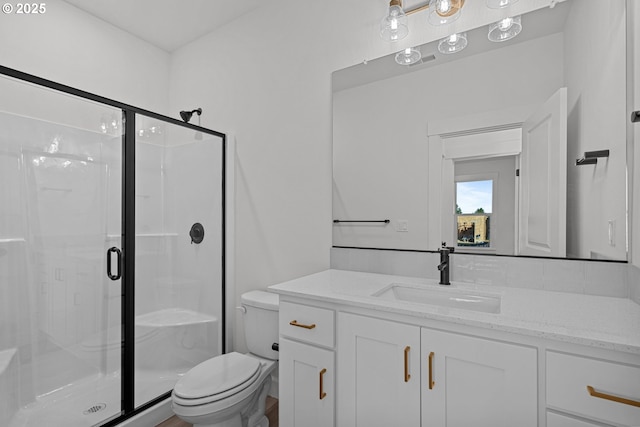 bathroom with vanity, toilet, and a shower with shower door