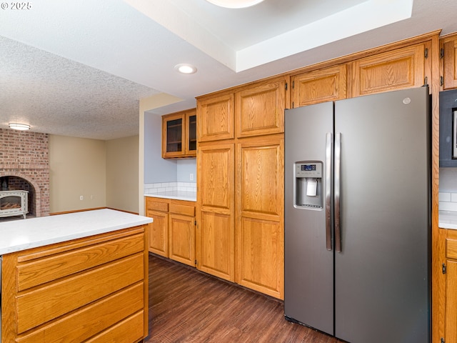 kitchen featuring stainless steel refrigerator with ice dispenser, light countertops, dark wood-style flooring, and brown cabinetry