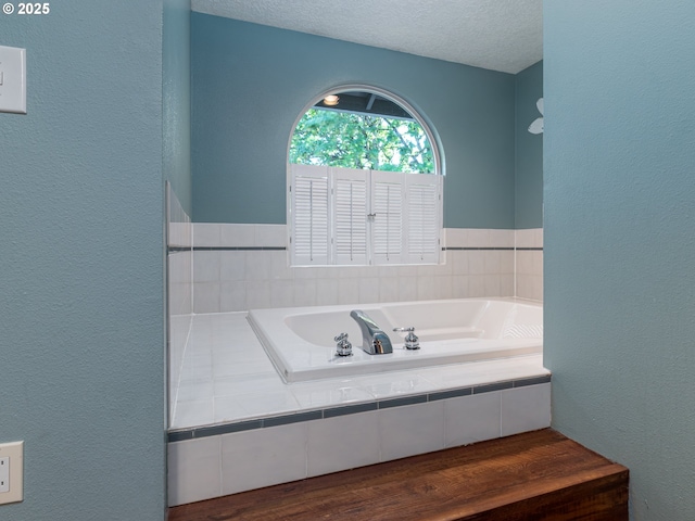 full bathroom with a textured ceiling and a bath
