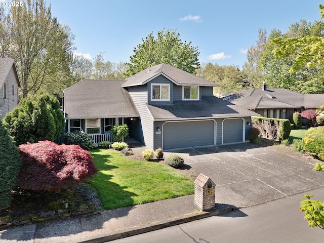 traditional-style home featuring covered porch, an attached garage, driveway, and a front yard