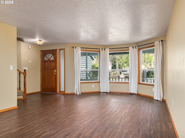 entryway featuring baseboards, dark wood-style floors, and a textured ceiling