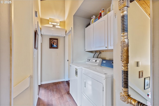 laundry area featuring cabinets, washer and dryer, and light wood-type flooring