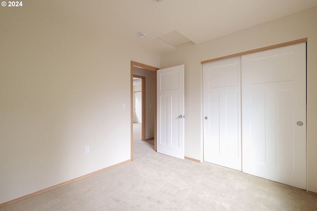 unfurnished bedroom featuring light colored carpet and a closet