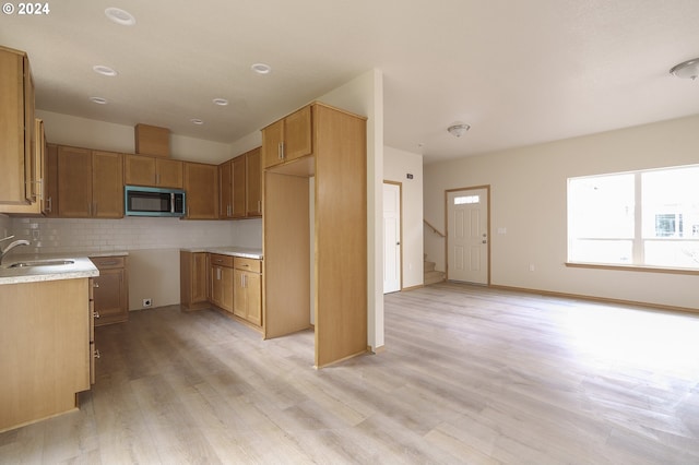 kitchen featuring sink, backsplash, and light hardwood / wood-style floors