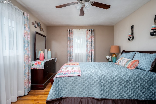 bedroom with light wood finished floors and a ceiling fan