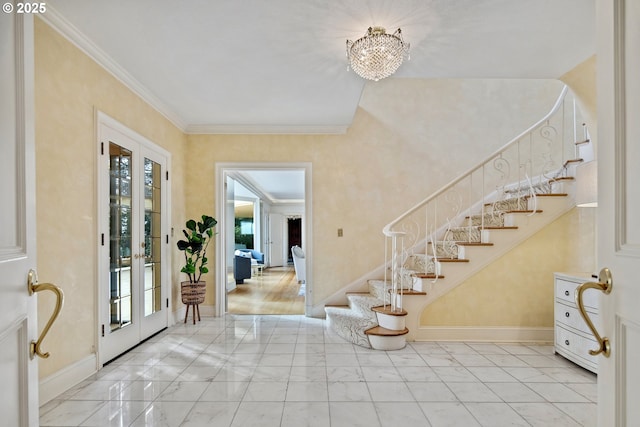 foyer entrance with baseboards, ornamental molding, and stairs